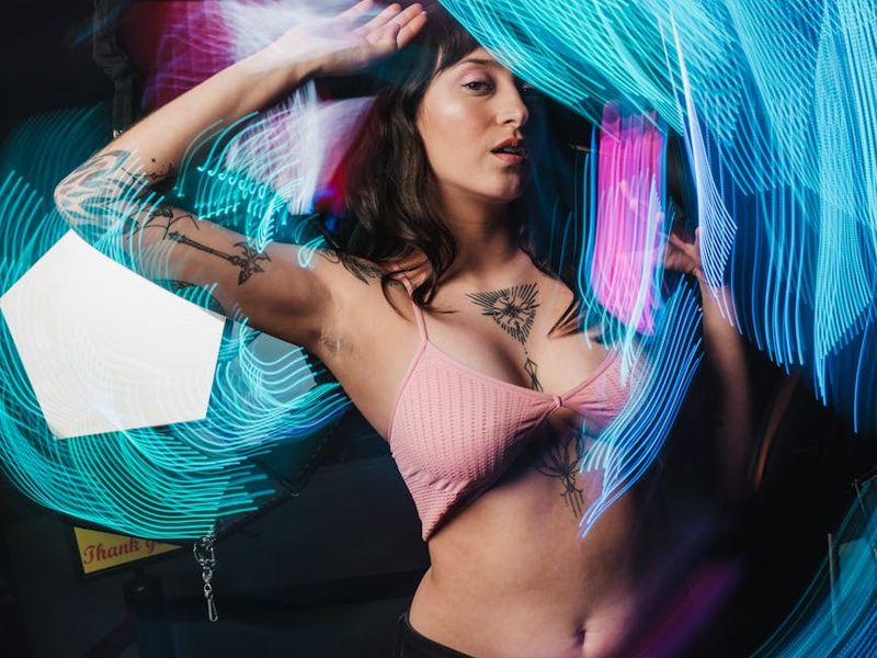 Person doing dynamic movements in a dark studio with neon lights